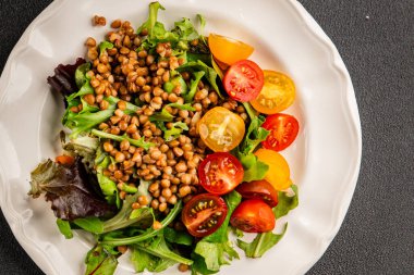 Mercimek salatası sebzeleri, domates, yeşil yaprak marul lezzetli aperatif lezzetli lezzetli gurme yemek masası kırsal üst görünüm fotokopi alanı keto ve paleo diyet vejetaryen ve vejetaryen yemekleri.