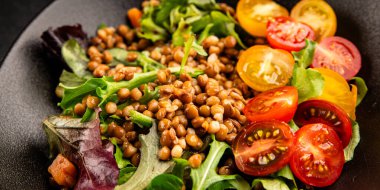 Mercimek salatası sebzeleri, domates, yeşil yaprak marul lezzetli aperatif lezzetli lezzetli gurme yemek masası kırsal üst görünüm fotokopi alanı keto ve paleo diyet vejetaryen ve vejetaryen yemekleri.