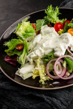 Burrata salatası domates, mor soğan, yeşil yaprak marul lezzetli aperatif taze gurme yemek masası kırsal yemek üst görünüm fotokopi alanı keto ve paleo diyet vejetaryen yemeği.