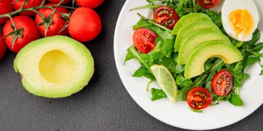Avokado salatası roka, yumurta, domates, karışık yeşillikler, sebzeler taze gurme yemek arka plan lezzetli yemek masa üstü kırsal yemek fotokopi alanı keto ve paleo diyeti vejetaryen yemeği