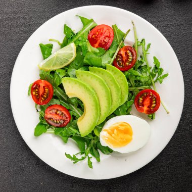 Avokado salatası roka, yumurta, domates, karışık yeşillikler, sebzeler taze gurme yemek arka plan lezzetli yemek masa üstü kırsal yemek fotokopi alanı keto ve paleo diyeti vejetaryen yemeği