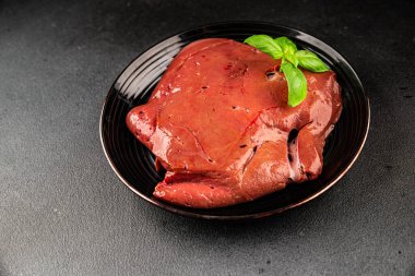 Karaciğer çiğ dana eti veya domuz eti sakatatı pişmiş doğal lezzetli aperatif taze lezzetli gurme yemek arkaplanı masa üzerinde rustik üst görünüm fotokopi alanı keto veya paleo diyeti