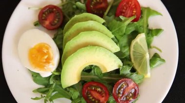 Avokado salatası roka, yumurta, domates, karışık yeşillikler, sebzeler taze yemek arka plan gurmesi masa üstü kırsal yemek fotokopi alanı keto ve paleo diyet vejetaryen yemeği.