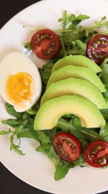 Avokado salatası roka, yumurta, domates, karışık yeşillikler, sebzeler taze yemek arka plan gurmesi masa üstü kırsal yemek fotokopi alanı keto ve paleo diyet vejetaryen yemeği.