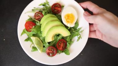 Avokado salatası roka, yumurta, domates, karışık yeşillikler, sebzeler taze yemek arka plan gurmesi masa üstü kırsal yemek fotokopi alanı keto ve paleo diyet vejetaryen yemeği.
