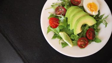 Avokado salatası roka, yumurta, domates, karışık yeşillikler, sebzeler taze yemek arka plan gurmesi masa üstü kırsal yemek fotokopi alanı keto ve paleo diyet vejetaryen yemeği.