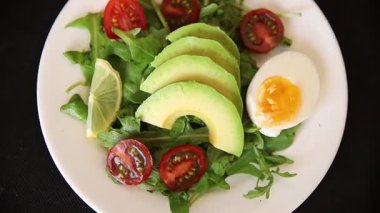 Avokado salatası roka, yumurta, domates, karışık yeşillikler, sebzeler taze yemek arka plan gurmesi masa üstü kırsal yemek fotokopi alanı keto ve paleo diyet vejetaryen yemeği.