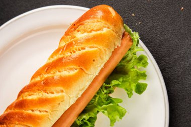 Sosisli sandviç taze çörek, sosis, yeşil marul yaprağı ev yapımı sandviç lezzetli aperatif lezzetli gurme yemek arkaplan masanın kırsal kesiminde fotokopi odası