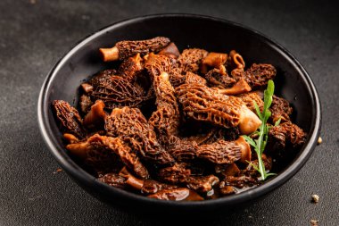Morels mantarları doğal mantarları sağlıklı yiyecekleri aperatifleri taze lezzetli gurme yemek arka planlarını masadaki rustik yiyecekleri fotokopi alanı keto ve paleo diyeti vejetaryen ve vejetaryen yemekleri.