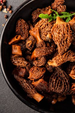 Morels mantarları doğal mantarları sağlıklı yiyecekleri aperatifleri taze lezzetli gurme yemek arka planlarını masadaki rustik yiyecekleri fotokopi alanı keto ve paleo diyeti vejetaryen ve vejetaryen yemekleri.
