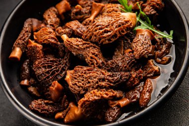 Morels mantarları doğal mantarları sağlıklı yiyecekleri aperatifleri taze lezzetli gurme yemek arka planlarını masadaki rustik yiyecekleri fotokopi alanı keto ve paleo diyeti vejetaryen ve vejetaryen yemekleri.