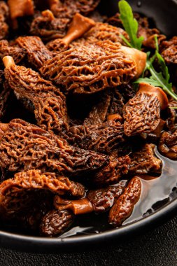 Morels mantarları doğal mantarları sağlıklı yiyecekleri aperatifleri taze lezzetli gurme yemek arka planlarını masadaki rustik yiyecekleri fotokopi alanı keto ve paleo diyeti vejetaryen ve vejetaryen yemekleri.