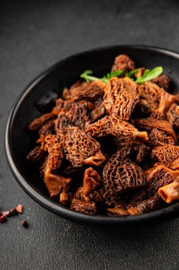 Morels mantarları doğal mantarları sağlıklı yiyecekleri aperatifleri taze lezzetli gurme yemek arka planlarını masadaki rustik yiyecekleri fotokopi alanı keto ve paleo diyeti vejetaryen ve vejetaryen yemekleri.