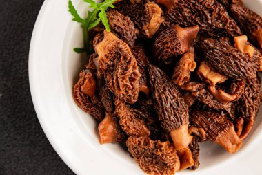 Morels mantarları doğal mantarları sağlıklı yiyecekleri aperatifleri taze lezzetli gurme yemek arka planlarını masadaki rustik yiyecekleri fotokopi alanı keto ve paleo diyeti vejetaryen ve vejetaryen yemekleri.