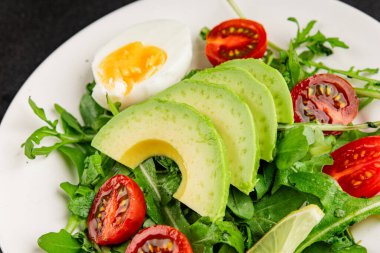 Avokado salatası roka, yumurta, domates, karışık yeşillikler, sebzeler taze gurme yemek arka plan lezzetli yemek masa üstü kırsal yemek fotokopi alanı keto ve paleo diyeti vejetaryen yemeği