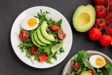 Avokado salatası roka, yumurta, domates, karışık yeşillikler, sebzeler taze gurme yemek arka plan lezzetli yemek masa üstü kırsal yemek fotokopi alanı keto ve paleo diyeti vejetaryen yemeği