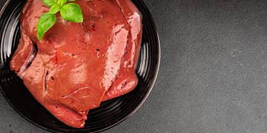 Karaciğer çiğ dana eti veya domuz eti sakatatı pişmiş doğal lezzetli aperatif taze lezzetli gurme yemek arkaplanı masa üzerinde rustik üst görünüm fotokopi alanı keto veya paleo diyeti