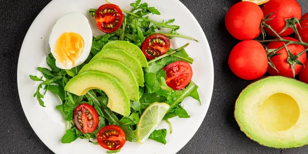 Avokado salatası roka, yumurta, domates, karışık yeşillikler, sebzeler taze gurme yemek arka plan lezzetli yemek masa üstü kırsal yemek fotokopi alanı keto ve paleo diyeti vejetaryen yemeği