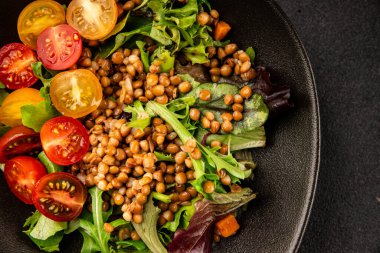 Mercimek salatası sebzeleri, domates, yeşil yaprak marul lezzetli aperatif lezzetli lezzetli gurme yemek masası kırsal üst görünüm fotokopi alanı keto ve paleo diyet vejetaryen ve vejetaryen yemekleri.