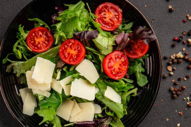 Parmesan peynirli sebze salatası domates, roka, yeşil yaprak marul sağlıklı yemek ana yemek aperatifi taze lezzetli gurme yemek arkaplanı masa rustik yemek üst görünüm uzay keto ve paleo diyet vejetaryen gıda