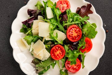 Parmesan peynirli sebze salatası domates, roka, yeşil yaprak marul sağlıklı yemek ana yemek aperatifi taze lezzetli gurme yemek arkaplanı masa rustik yemek üst görünüm uzay keto ve paleo diyet vejetaryen gıda