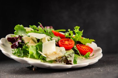Parmesan peynirli sebze salatası domates, roka, yeşil yaprak marul sağlıklı yemek ana yemek aperatifi taze lezzetli gurme yemek arkaplanı masa rustik yemek üst görünüm uzay keto ve paleo diyet vejetaryen gıda