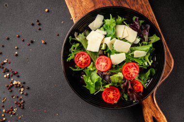 Parmesan peynirli sebze salatası domates, roka, yeşil yaprak marul sağlıklı yemek ana yemek aperatifi taze lezzetli gurme yemek arkaplanı masa rustik yemek üst görünüm uzay keto ve paleo diyet vejetaryen gıda