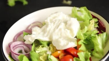 Burrata salatası domates, mor soğan, yeşil yaprak marul lezzetli aperatif taze gurme yemek masası kırsal yemek üst görünüm fotokopi alanı keto ve paleo diyet vejetaryen yemeği.