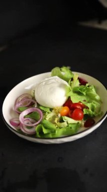 Burrata salatası domates, mor soğan, yeşil yaprak marul lezzetli aperatif taze gurme yemek masası kırsal yemek üst görünüm fotokopi alanı keto ve paleo diyet vejetaryen yemeği.