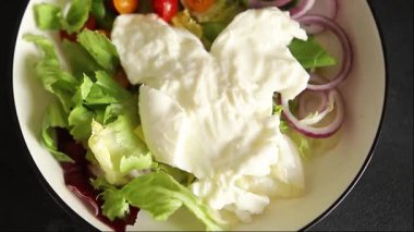 Burrata salatası domates, mor soğan, yeşil yaprak marul lezzetli aperatif taze gurme yemek masası kırsal yemek üst görünüm fotokopi alanı keto ve paleo diyet vejetaryen yemeği.