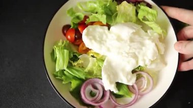 Burrata salatası domates, mor soğan, yeşil yaprak marul lezzetli aperatif taze gurme yemek masası kırsal yemek üst görünüm fotokopi alanı keto ve paleo diyet vejetaryen yemeği.