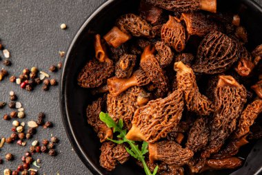 Morels mantarları doğal mantarları sağlıklı yiyecekleri aperatifleri taze lezzetli gurme yemek arka planlarını masadaki rustik yiyecekleri fotokopi alanı keto ve paleo diyeti vejetaryen ve vejetaryen yemekleri.