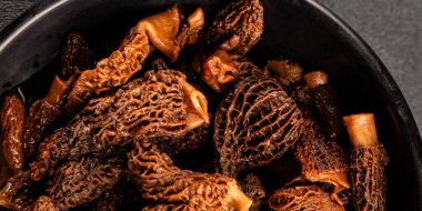 Morels mantarları doğal mantarları sağlıklı yiyecekleri aperatifleri taze lezzetli gurme yemek arka planlarını masadaki rustik yiyecekleri fotokopi alanı keto ve paleo diyeti vejetaryen ve vejetaryen yemekleri.