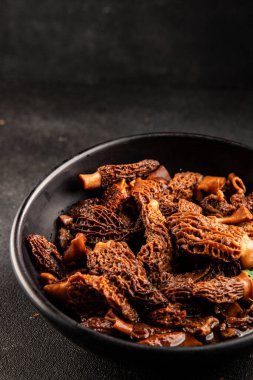 Morels mantarları doğal mantarları sağlıklı yiyecekleri aperatifleri taze lezzetli gurme yemek arka planlarını masadaki rustik yiyecekleri fotokopi alanı keto ve paleo diyeti vejetaryen ve vejetaryen yemekleri.