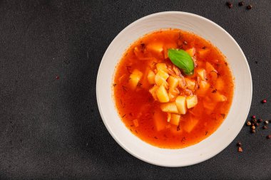 Red soup vegetables potatoes, tomato, broth first course borscht tasty snack fresh delicious gourmet food background on the table rustic food top view copy space keto and paleo diet vegetarian and vegan food