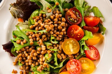 Mercimek salatası sebzeleri, domates, yeşil yaprak marul lezzetli aperatif lezzetli lezzetli gurme yemek masası kırsal üst görünüm fotokopi alanı keto ve paleo diyet vejetaryen ve vejetaryen yemekleri.