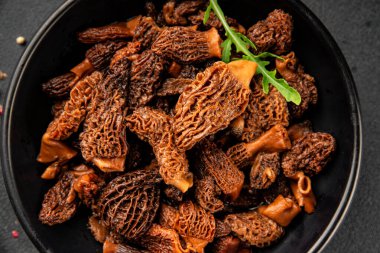 Morels mantarları doğal mantarları sağlıklı yiyecekleri aperatifleri taze lezzetli gurme yemek arka planlarını masadaki rustik yiyecekleri fotokopi alanı keto ve paleo diyeti vejetaryen ve vejetaryen yemekleri.