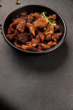 Morels mantarları doğal mantarları sağlıklı yiyecekleri aperatifleri taze lezzetli gurme yemek arka planlarını masadaki rustik yiyecekleri fotokopi alanı keto ve paleo diyeti vejetaryen ve vejetaryen yemekleri.