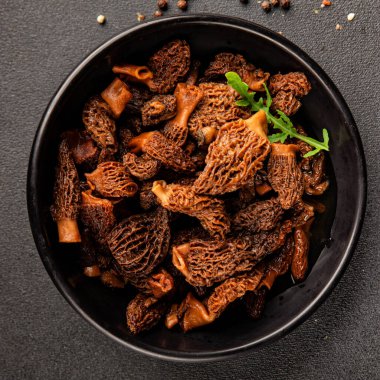 Morels mantarları doğal mantarları sağlıklı yiyecekleri aperatifleri taze lezzetli gurme yemek arka planlarını masadaki rustik yiyecekleri fotokopi alanı keto ve paleo diyeti vejetaryen ve vejetaryen yemekleri.