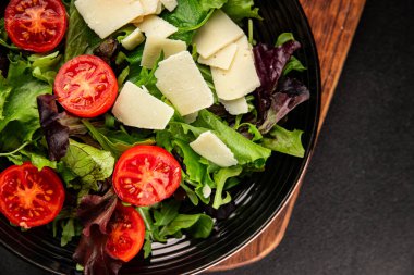 Parmesan peynirli sebze salatası domates, roka, yeşil yaprak marul sağlıklı yemek ana yemek aperatifi taze lezzetli gurme yemek arkaplanı masa rustik yemek üst görünüm uzay keto ve paleo diyet vejetaryen gıda