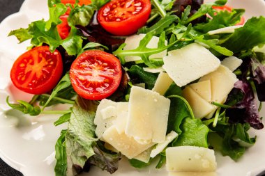 Parmesan peynirli sebze salatası domates, roka, yeşil yaprak marul sağlıklı yemek ana yemek aperatifi taze lezzetli gurme yemek arkaplanı masa rustik yemek üst görünüm uzay keto ve paleo diyet vejetaryen gıda