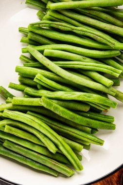 Taze taze fasulye taze sebze fasulyesi sağlıklı yemek aperatifi taze lezzetli gurme masası yemek arkaplanı hazırlıyor rustik üst görünüm fotokopi alanı keto ve paleo diyet vejetaryen ve vejetaryen yemekleri.