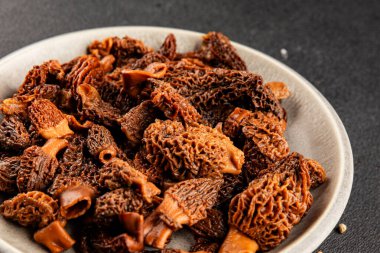 Morels mantarları doğal mantarları sağlıklı yiyecekleri aperatifleri taze lezzetli gurme yemek arka planlarını masadaki rustik yiyecekleri fotokopi alanı keto ve paleo diyeti vejetaryen ve vejetaryen yemekleri.