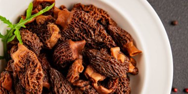 Morels mantarları doğal mantarları sağlıklı yiyecekleri aperatifleri taze lezzetli gurme yemek arka planlarını masadaki rustik yiyecekleri fotokopi alanı keto ve paleo diyeti vejetaryen ve vejetaryen yemekleri.