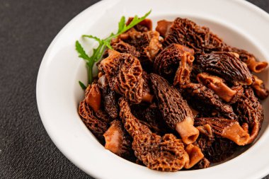 Morels mantarları doğal mantarları sağlıklı yiyecekleri aperatifleri taze lezzetli gurme yemek arka planlarını masadaki rustik yiyecekleri fotokopi alanı keto ve paleo diyeti vejetaryen ve vejetaryen yemekleri.