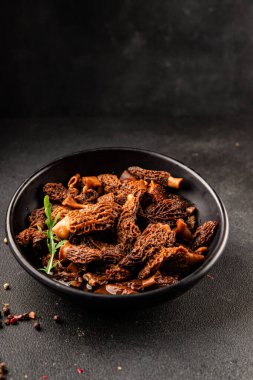 Morels mantarları doğal mantarları sağlıklı yiyecekleri aperatifleri taze lezzetli gurme yemek arka planlarını masadaki rustik yiyecekleri fotokopi alanı keto ve paleo diyeti vejetaryen ve vejetaryen yemekleri.