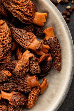 Morels mantarları doğal mantarları sağlıklı yiyecekleri aperatifleri taze lezzetli gurme yemek arka planlarını masadaki rustik yiyecekleri fotokopi alanı keto ve paleo diyeti vejetaryen ve vejetaryen yemekleri.