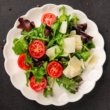Parmesan peynirli sebze salatası domates, roka, yeşil yaprak marul sağlıklı yemek ana yemek aperatifi taze lezzetli gurme yemek arkaplanı masa rustik yemek üst görünüm uzay keto ve paleo diyet vejetaryen gıda