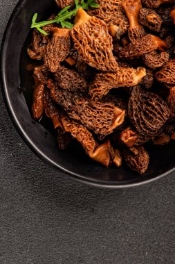 Morels mantarları doğal mantarları sağlıklı yiyecekleri aperatifleri taze lezzetli gurme yemek arka planlarını masadaki rustik yiyecekleri fotokopi alanı keto ve paleo diyeti vejetaryen ve vejetaryen yemekleri.