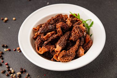 Morels mantarları doğal mantarları sağlıklı yiyecekleri aperatifleri taze lezzetli gurme yemek arka planlarını masadaki rustik yiyecekleri fotokopi alanı keto ve paleo diyeti vejetaryen ve vejetaryen yemekleri.